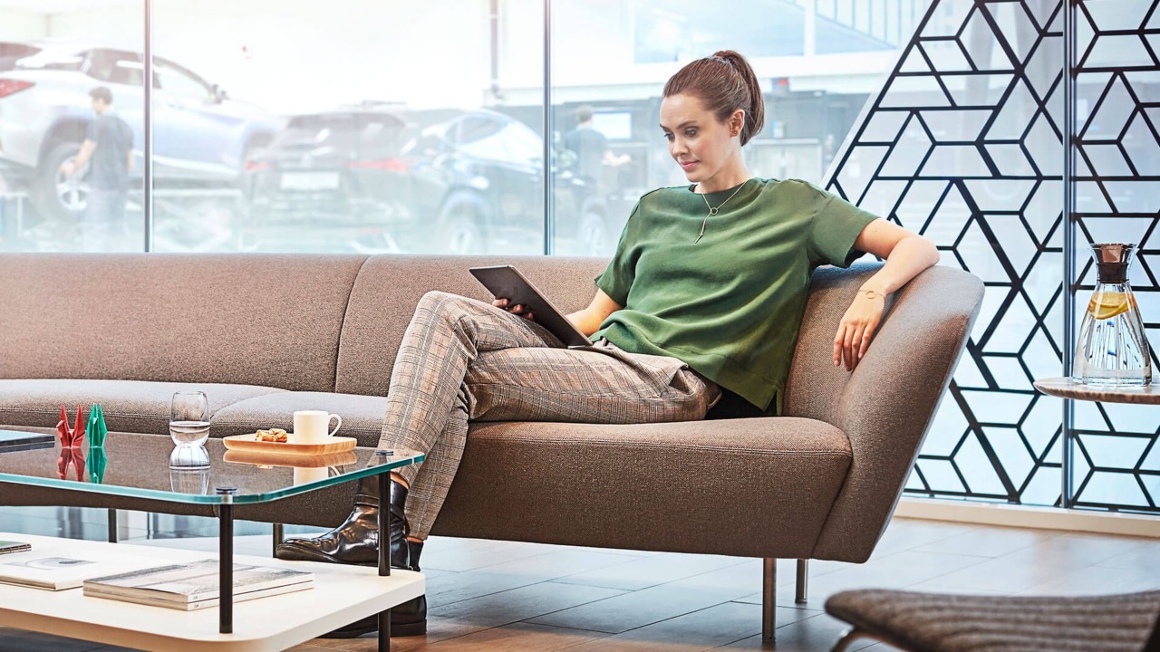 A woman sat on a sofa in a Lexus dealership
